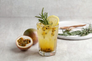 A glass of Iced passion fruit soda with lemon and passion fruit half slice